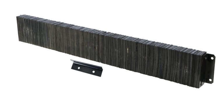A large stack of industrial metal staples is perfectly aligned like a Vestil Laminated Dock Bumper 12 X 96 X 4.5 In, with one loose staple beside it. The surface has a slightly reflective, metallic sheen.