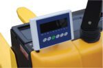 Close-up of a digital control panel on a yellow Vestil Electric Truck W/Scale Optional Printer. It includes a black screen and symbol-labeled buttons for precise scaling, with an armrest and joystick on the right against a white background.