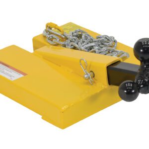 The Vestil Fork Lift Hitch Attachment is a yellow trailer hitch adapter featuring a black cube with three diverse-sized towing balls, and is secured by a silver chain wrapped around its base, alongside a caution label on the yellow metal.