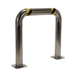 A shiny metallic U-shaped safety barrier, similar to the Vestil Ss High Profile Rack Guard 36 X 36 X 4, is adorned with yellow and black caution tape at the top and has two flat mounting bases for easy surface securing.
