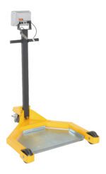 The Vestil Low Profile Drum Caddy W/ Scale is a yellow industrial platform scale with a digital display on a tall black metal stand. Its designed for large objects and features a wide metallic platform with wheels for easy mobility.
