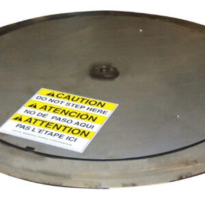 A large metal manhole cover, akin to the robustness of a Vestil Pallet Trk Thin Spin Carousel Ss 54 In, displays a yellow, white, and black caution label stating Do Not Step Here, clearly visible in English, Spanish, and French.