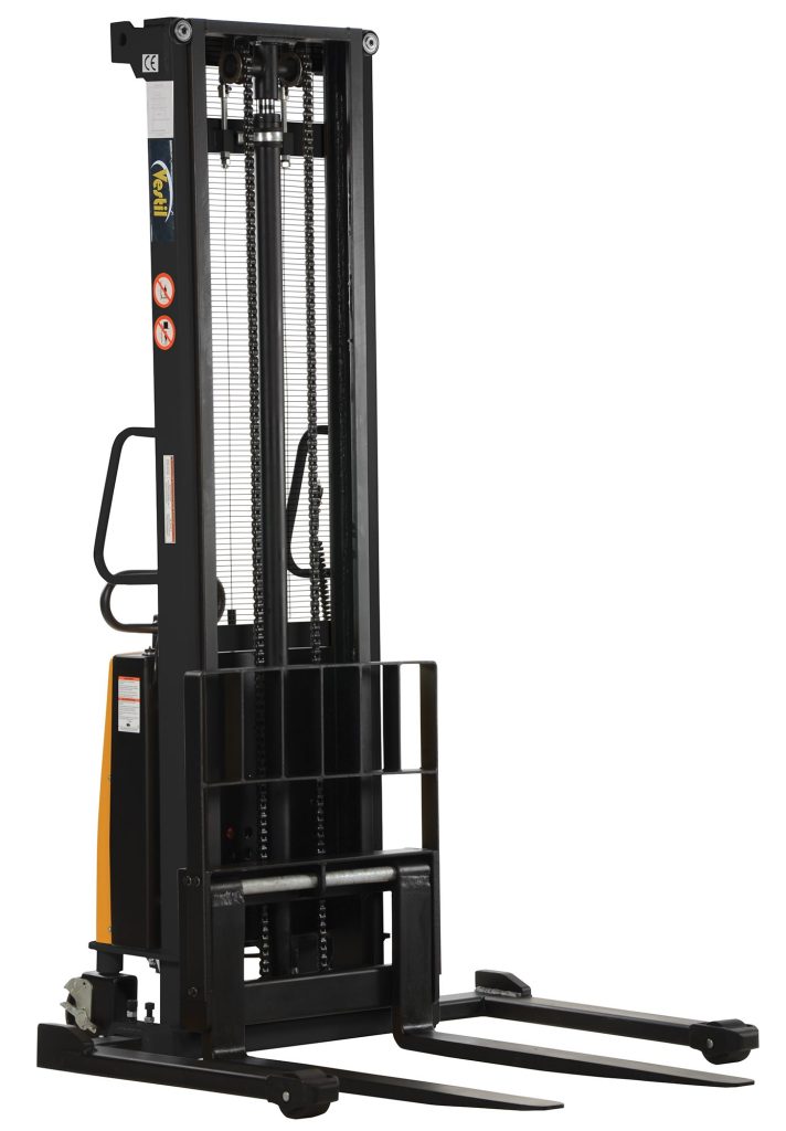 The Vestil Adjustable Stacker W/Powered Lift 150 In is a black stacker with two prongs, a powered lift, vertical mast with chains and gears, side hand controls, caution labels, and an industrial design.