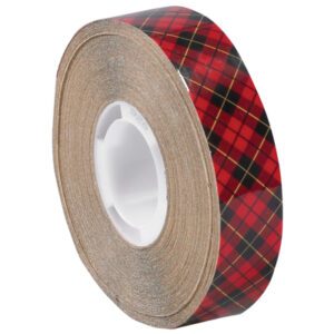 A roll of 1/2 x 18 yds. 3M™ 926 Adhesive Transfer Tape, with its distinct red and black plaid pattern, features a white circular core and partially unwound sticky side. Available in a case of 72 rolls.