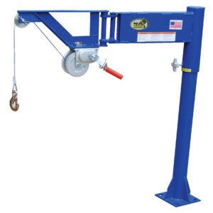 The blue Vestil Manual Lifter Jib has a 400 lb capacity, features a hand-operated winch with a wire rope ending in a hook, and is mounted on a stable base. It sports an American flag sticker and brand label on its arm.