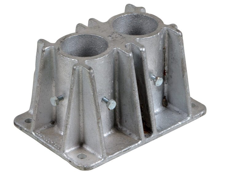 The Vestil Steel Pipe Safety Railing Double Socket includes a metal bracket with dual cylindrical openings and ribbed sides, a flat base with four bolt holes for mounting, and two small side bolts to secure the structure.
