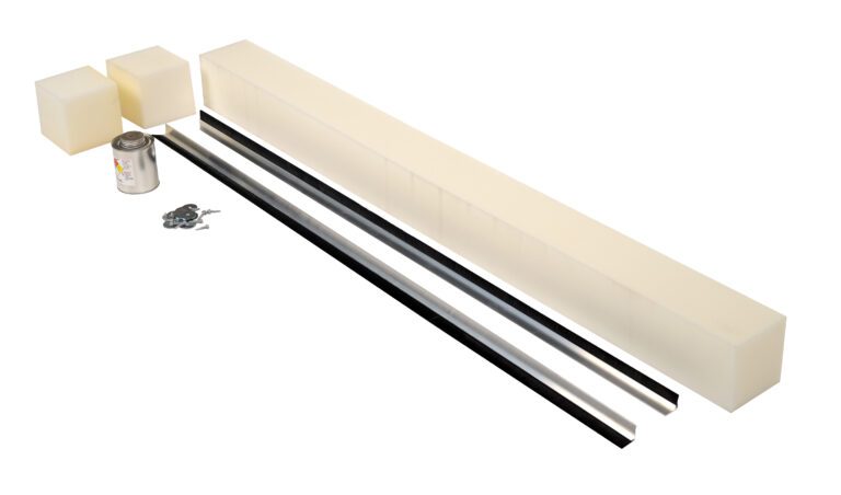 Two large foam rectangles, two small cubes, and a can are arranged beside three rods in black, silver, and white. Scattered metallic parts look like pieces from the Vestil Stripping Replace 1 In Brush 85 In Pit kit. All items are set against a pristine white background.