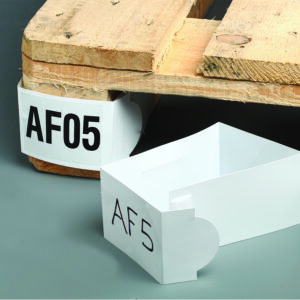 A wooden pallet with an AF05 tag is attached to a corner, while a similar loose MH-USA Pallet Marker - White - H.2.95 in. x W.18.5 in., Pack of 50, labeled AF5, rests on the gray floor nearby.