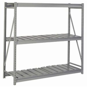A large, empty industrial metal shelving unit with three levels and open sides. The shelves are made of parallel slats, and the unit is supported by a sturdy frame with cross braces. The color is a muted gray.