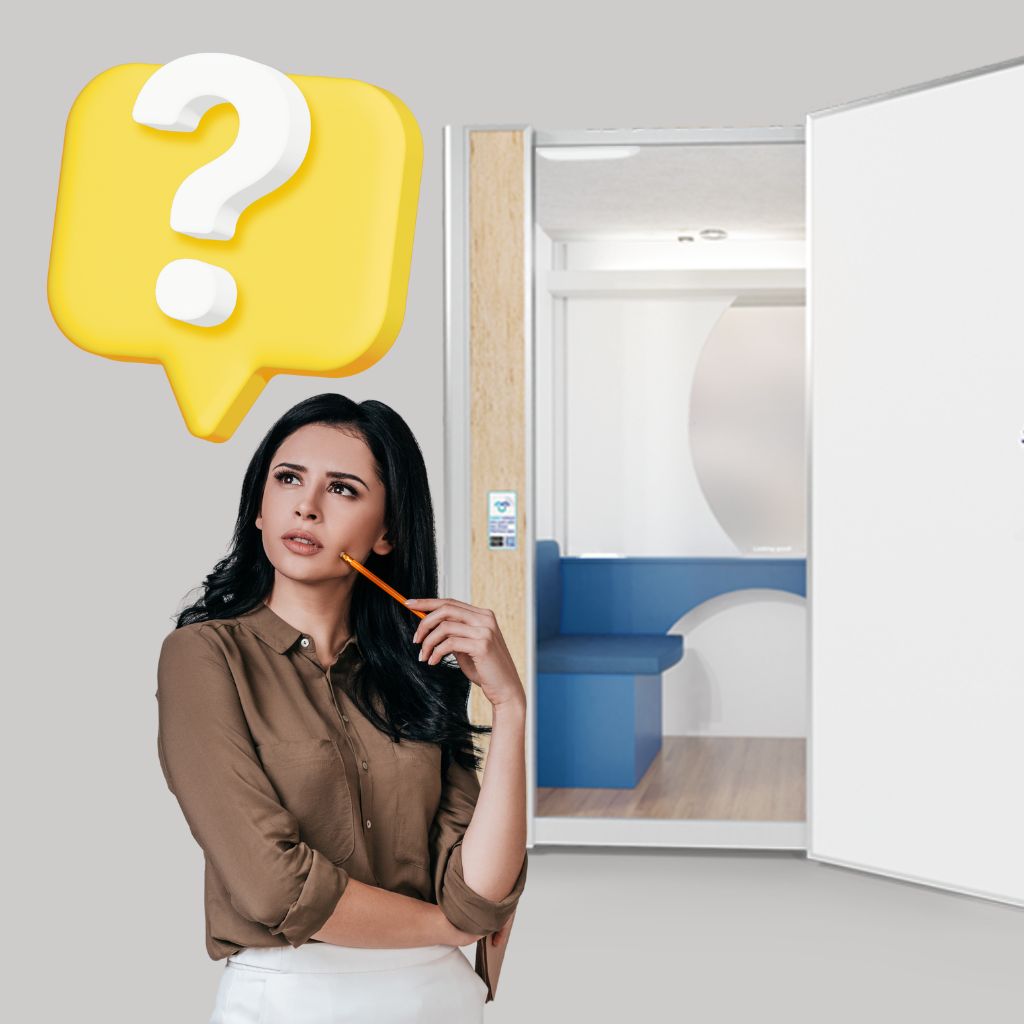 A woman holding a pencil thoughtfully gazes at a large yellow question mark. She stands by an open door leading to a modern room with blue seating and an ADA Lactation Pod. The background is a neutral light gray, suggesting possibilities beyond the ordinary.