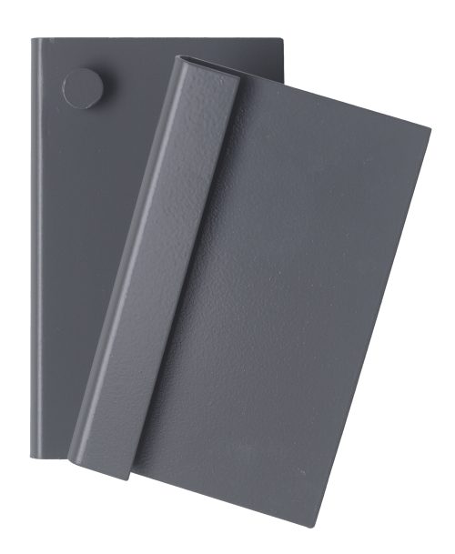 QTB-LP-BKT_GY.jpg Two overlapping dark gray books rest on a white surface, subtly resembling the sleek design of the Quantum Louvered Panel Bracket for QTB Tip-Out Bins. The top book is slightly tilted over the other, with a small circular object at its upper left corner.