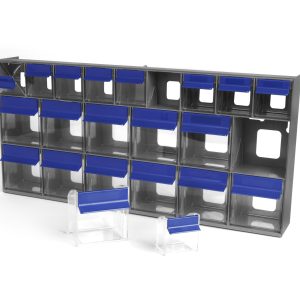 The Quantum Tip Out Bin features 21 compartments with clear plastic drawers and blue handles with label slots. Some drawers are open or removed, placed in front of the gray polystyrene cabinet on a white background. The bin measures 23-5/8W x 11-1/6D x 3-5/8H and is made in the USA.